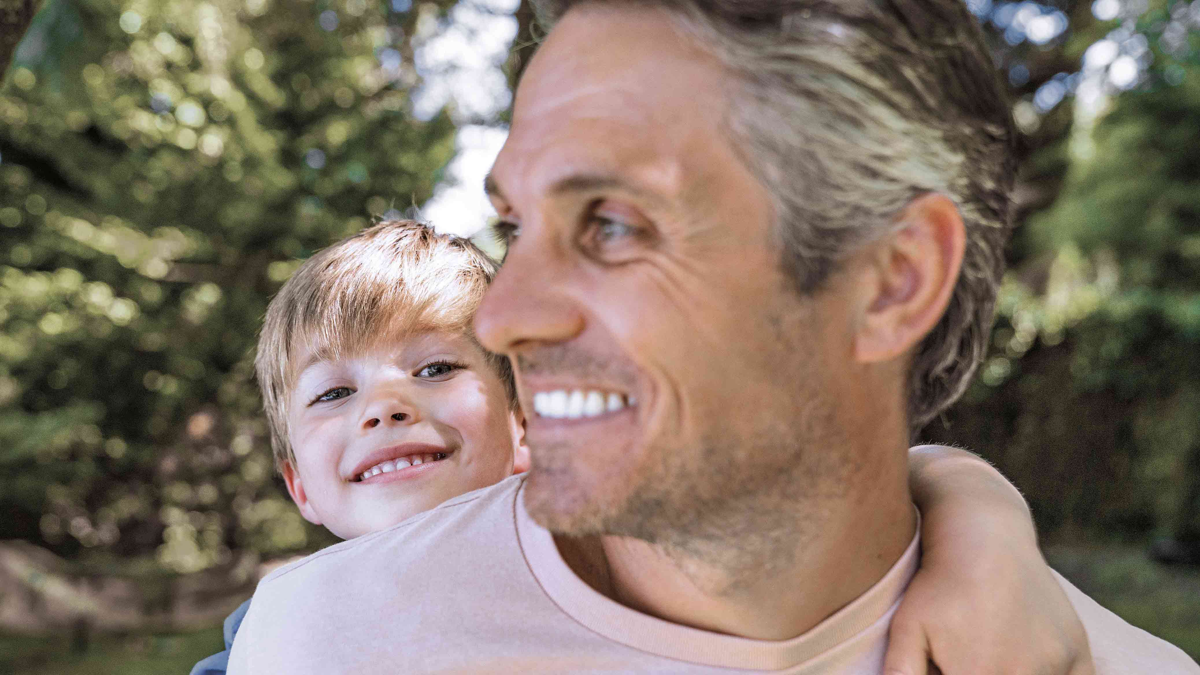 Smiling man with child on his back
