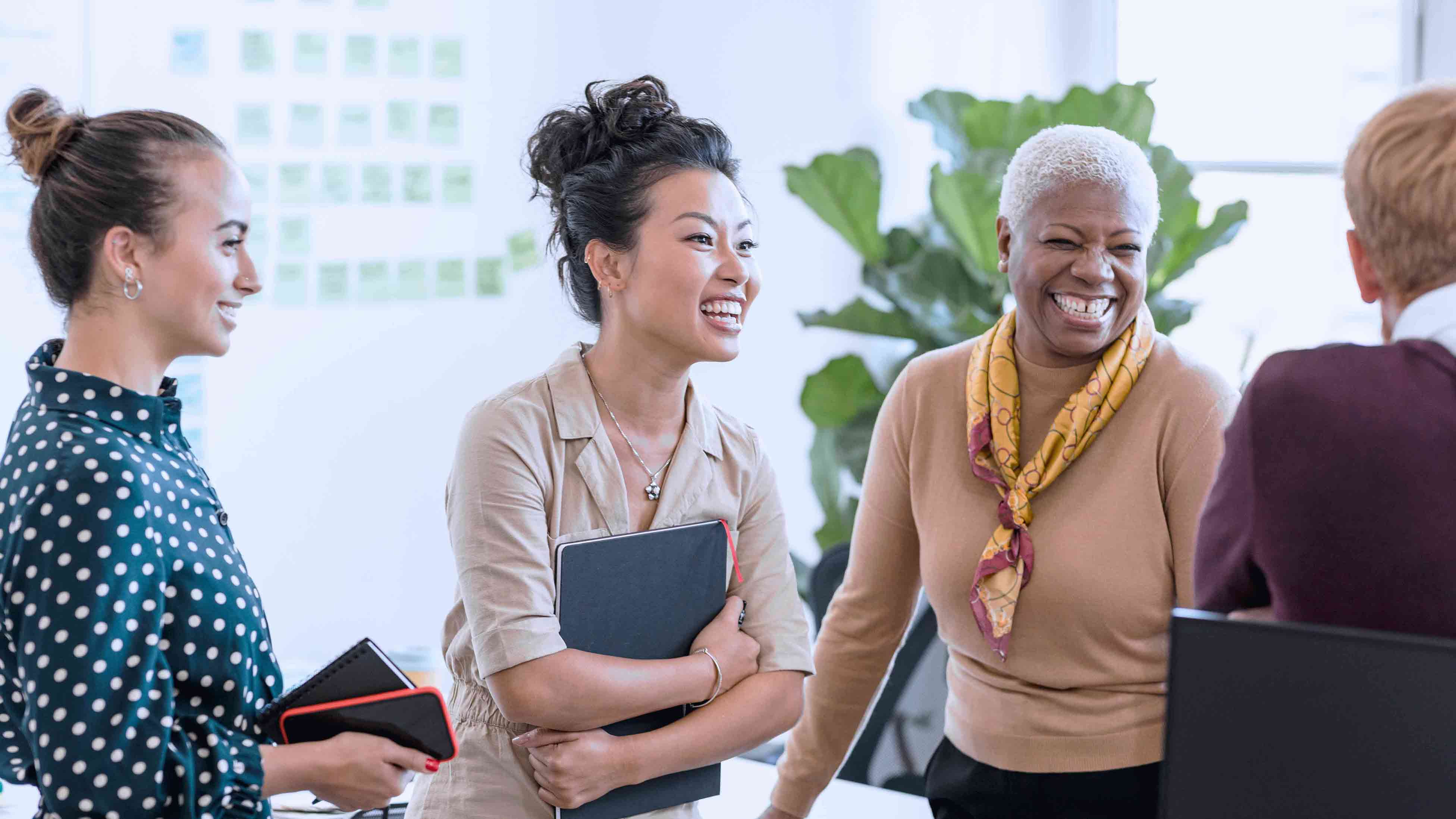 Colleagues standing and laughing in an office 