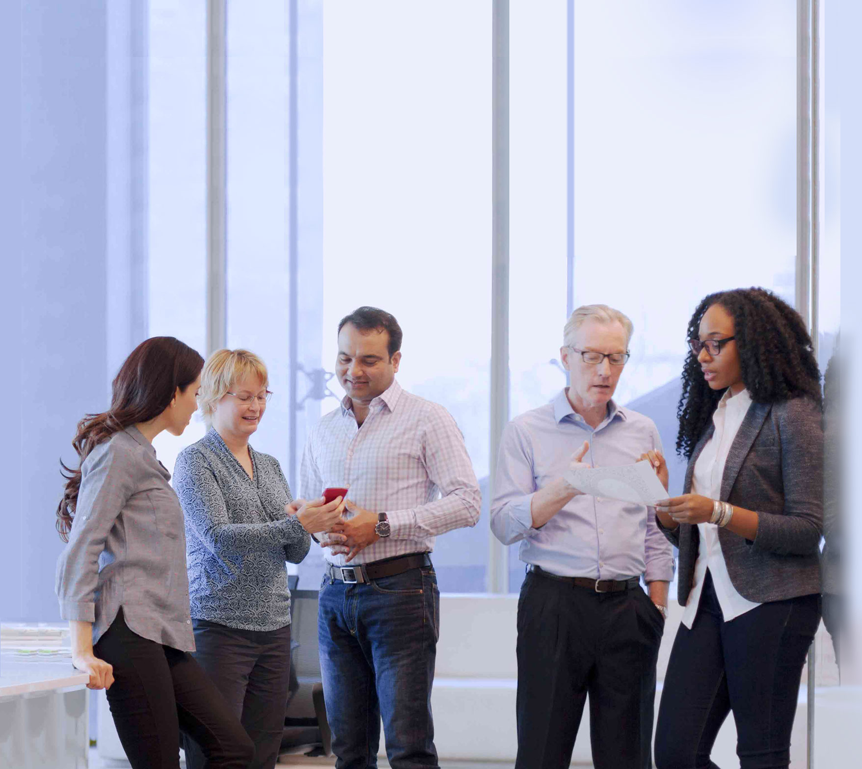 Colleagues standing discussing a document