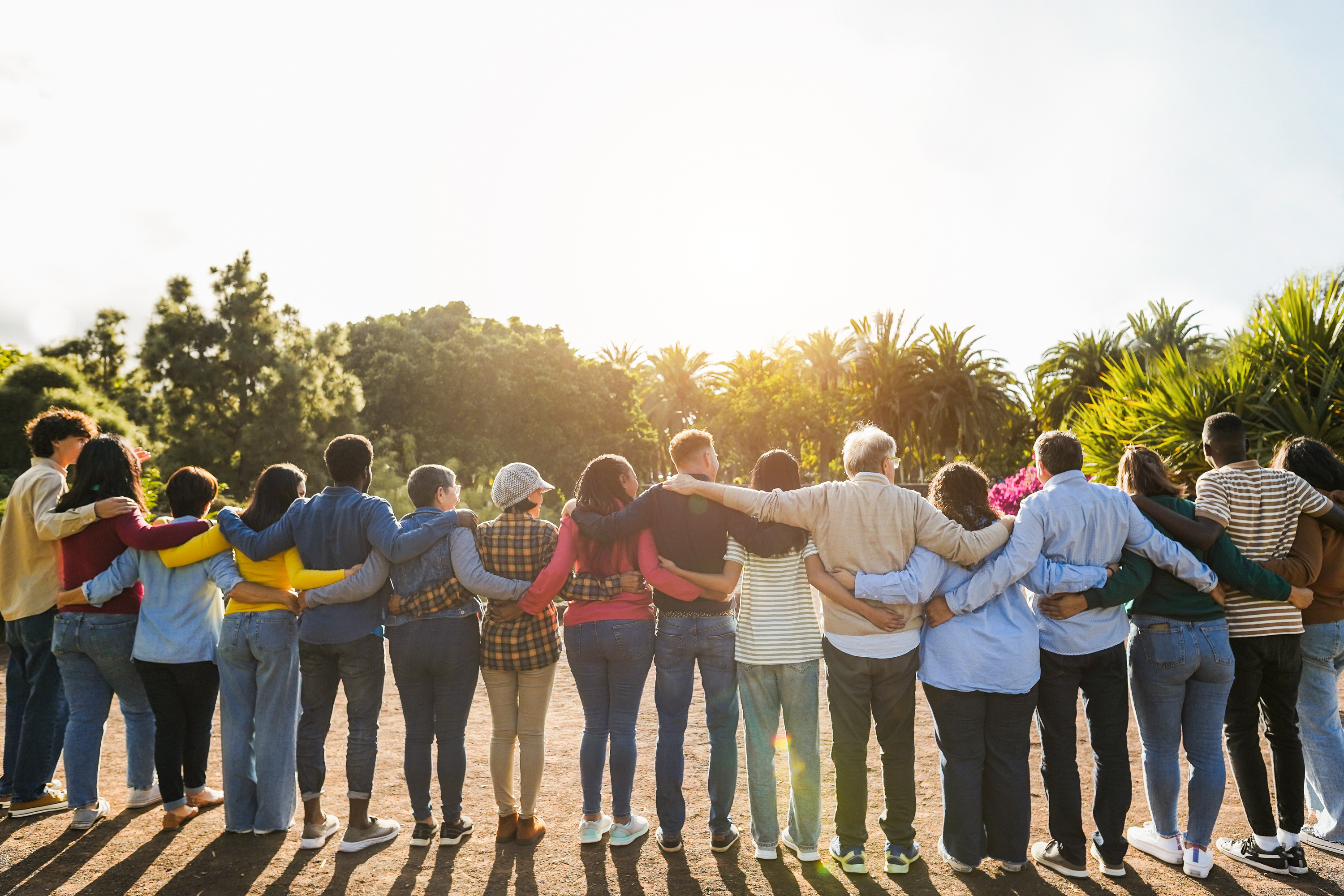 Image of people in a line with arms wrapped around each other’s back.