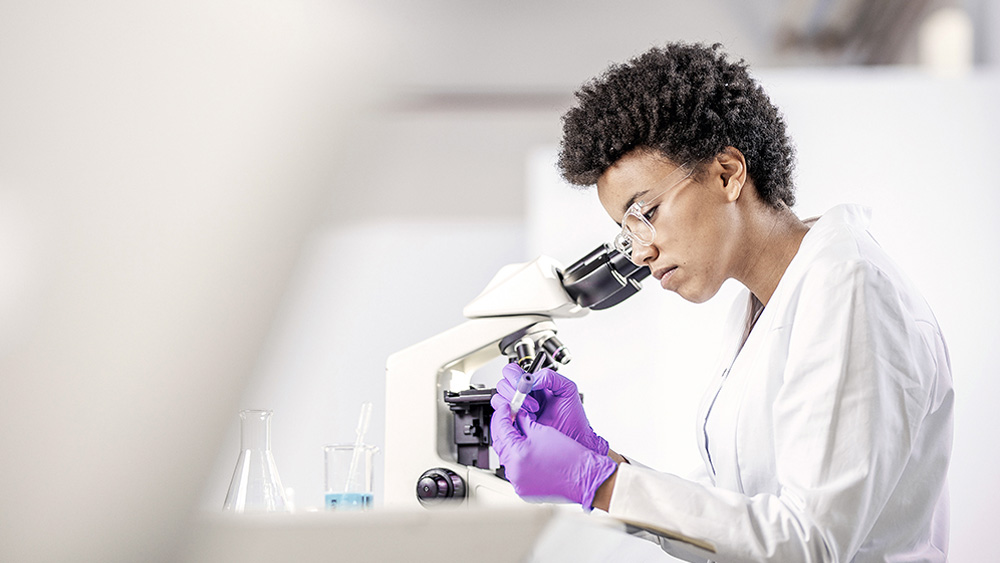 Image of woman looking into microscope.
