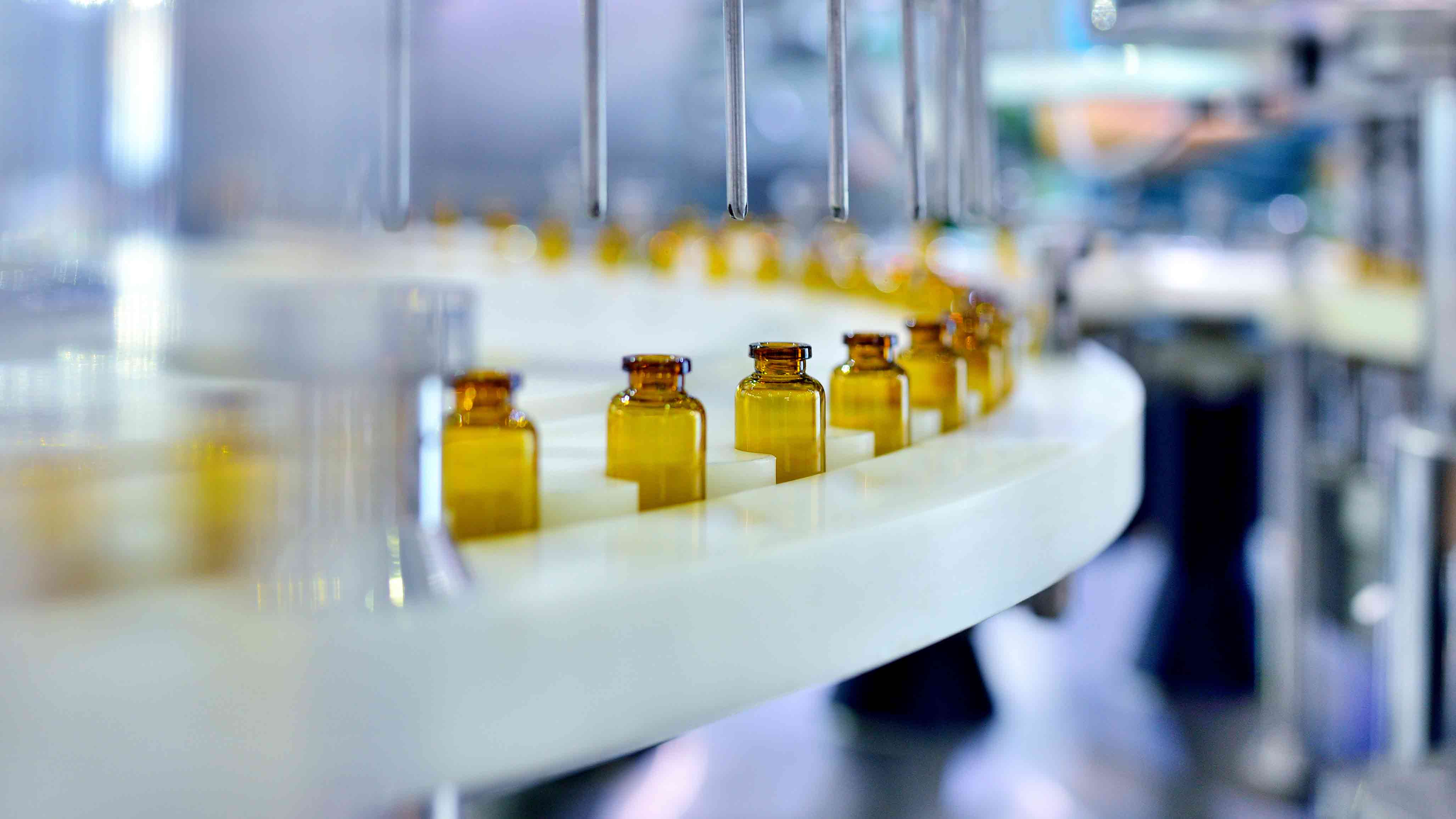 Yellow vials on a manufacturing conveyer belt